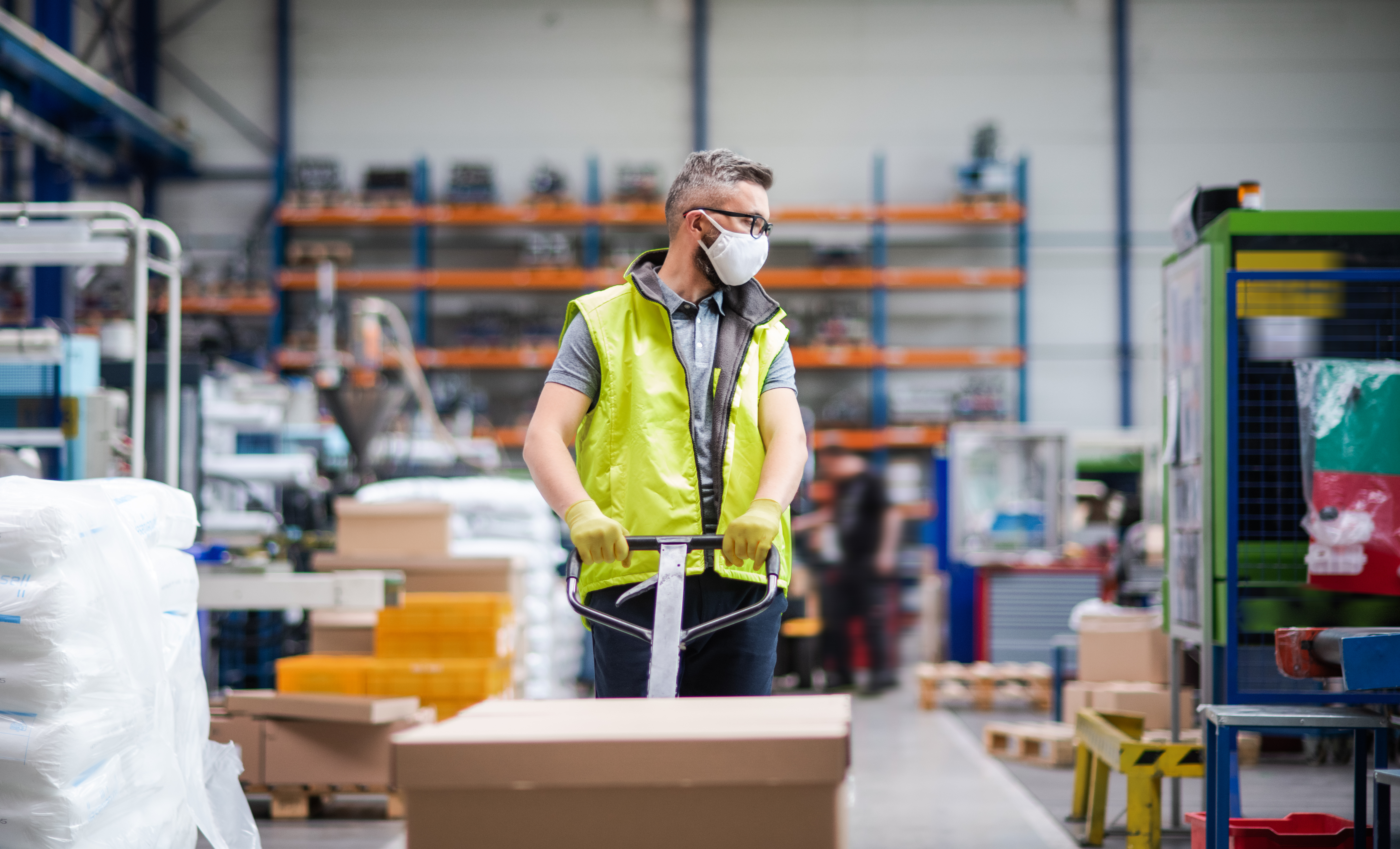 Man worker with protective mask working in industrial factory or warehouse